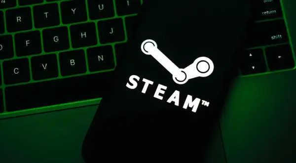 Telefon z logo Steam na tle zielonej klawiatury.