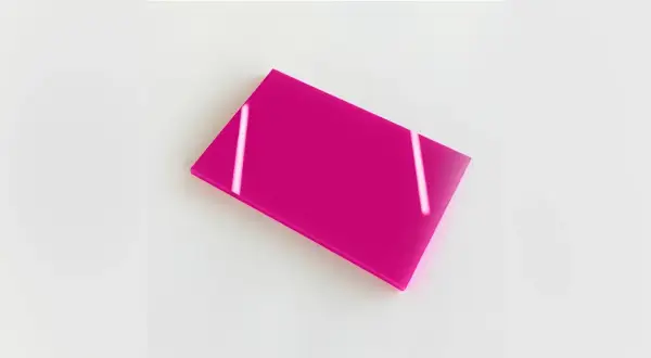 Plaque de plexiglas coloré rose vif, reflétant la lumière.