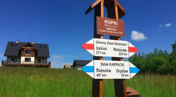 Rozdroże szlaków GSB i Karpackiego w Ropkach. Wskazówki pokazują kierunki do Ustronia, Wołosatego, Rzeszowa i Grybowa.