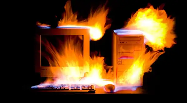 Płonący komputer z lat 2000. i klawiatura, jakby przegrzewały się od emocjonujących, **stare gry na PC lata 2000.**