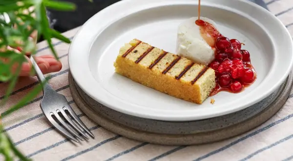 Grillad sockerkaka med vaniljglass, rårörda lingon och en sirap som påminner om ett kardemumma recept.