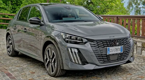 Szary Peugeot 208 na brukowanej drodze. Sprawdź aktualną peugeot 208 cena i wybierz swój wymarzony samochód.