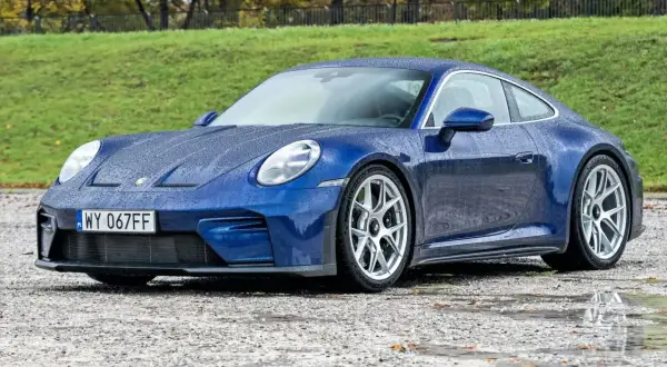 Niebieski Porsche 911 na mokrej nawierzchni. Sprawdź aktualną porsche 911 cena.