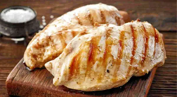 Petto di pollo alla griglia, perfetti secondi di carne da preparare in anticipo. Un contorno di sale completa l'immagine.