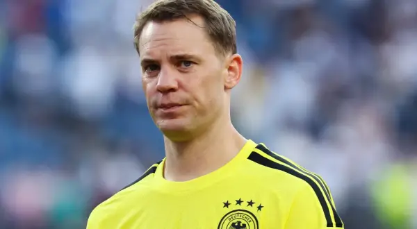Manuel Neuer, bramkarz w żółtej koszulce z czarnymi pasami, gotowy do gry.