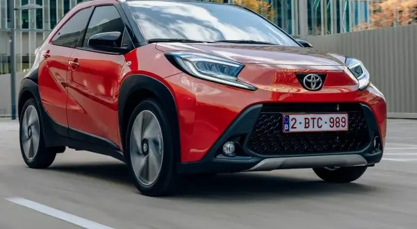 Czerwony Toyota Aygo w ruchu miejskim. Wiele osób szuka toyota aygo opinie, by poznać ten model.