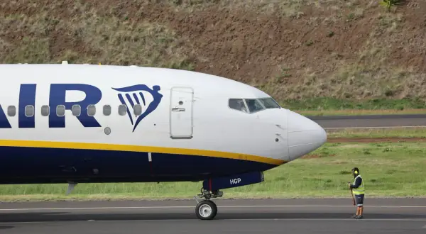 Un avion Ryanair sur le tarmac, prêt pour sa prochaine **reclamation**. Un agent au sol veille.