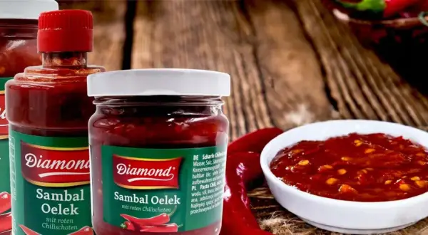 Słoiki z pikantnym sosem Sambal Oelek, z widocznymi papryczkami chili. Idealny do potraw, które potrzebują odrobiny ostrości.