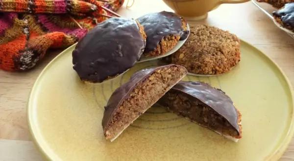 Schokoladen-Lebkuchen, ein köstliches Lebkuchen Rezept ohne Mehl, liegen auf einem Teller neben Strickzeug und einer Tasse.