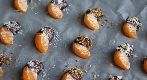 Söta klyftor av apelsin doppade i mörk choklad och strössel, redo att avnjutas. Ett enkelt sätt att baka med choklad!