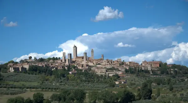 San Gimignano mit seinen Türmen, umgeben von Olivenhainen. Entdecken Sie die Geheimtipps dieser toskanischen Stadt.