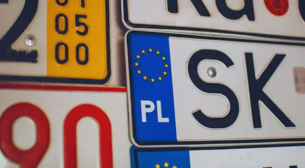 Kolekcja tablic rejestracyjnych, w tym polska z symbolem UE i oznaczeniem PL.