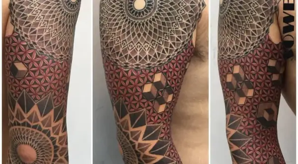 Brazo con tatuajes tradi geométricos, mandalas y flor de la vida en rojo y negro.