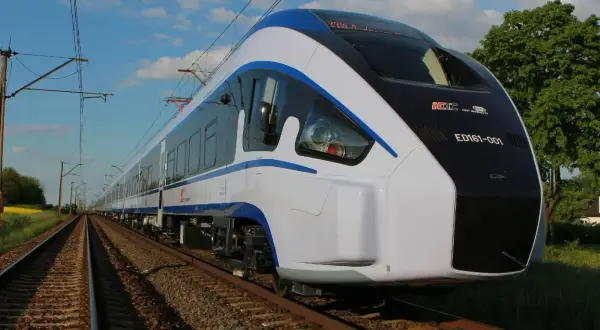 Nowoczesny pociąg ED161-001, najszybszy pociąg w Polsce, mknie po torach wśród zieleni.