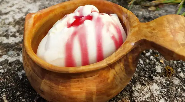 Krämig glass med röd sås i en träskål. Ett enkelt glass recept som passar perfekt efter en dag med glassmaskin.