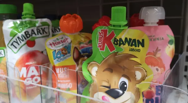 Czy musy owocowe są zdrowe dla dorosłych? Na półce widać różne musy owocowe, m.in. Kubuś banan jabłko, Tymbark, Hortex.