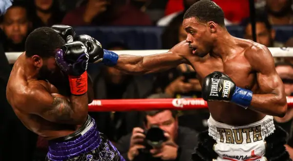A boxer lands a powerful punch, while his opponent attempts to block with a jab. The intensity of the jab vs punch is palpable.