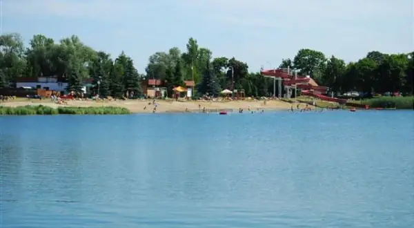 Letnia plaża z czerwonymi zjeżdżalniami wodnymi nad jeziorem, popularne miejsce wypoczynku, Morskie Oko Wrocław.