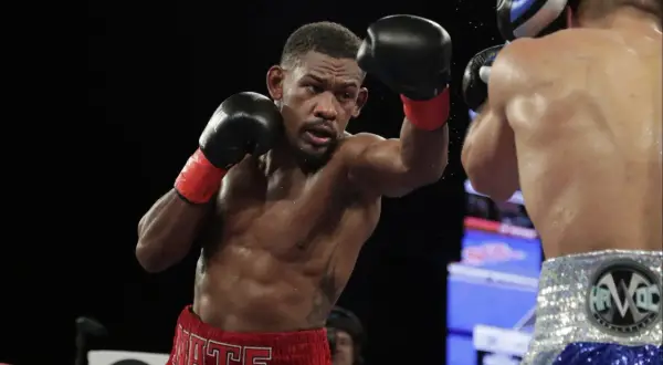 Jacobs boxer, Daniel Jacobs, throws a punch during a boxing match, sweat glistening on his muscular physique.