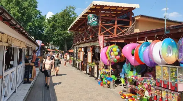 Skorzęcin atrakcje: kolorowe koła do pływania, zabawki i budki z grami na deptaku. Słoneczny dzień zachęca do spacerów.
