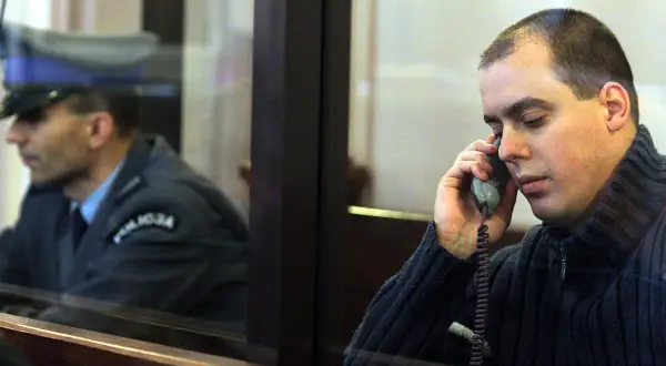 Mężczyzna rozmawia przez telefon, w tle widać funkcjonariusza. Ciekawe, ile lat ma misiek z Nadarzyna?