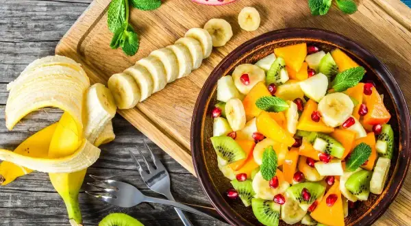 Kolorowa sałatka owocowa z kiwi, bananem, mango i granatem. Idealna na deser, zastanawiasz się, jaki sos do sałatki owocowej będzie najlepszy?