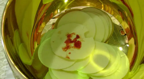 Hostia z plamą przypominającą krew, symbolizująca cud eucharystyczny w Sokółce, w złotym naczyniu.