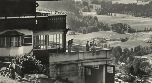 Blick vom Berghof Obersalzberg auf das malerische Tal. Menschen genießen die Aussicht von der Terrasse.