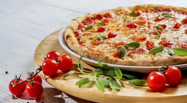 Szukasz miejsca, gdzie dobrze i tanio zjeść w Mikołajkach? Ta pyszna pizza z pomidorkami i bazylią to idealna propozycja!