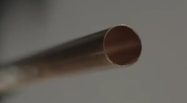 Extrémité d'un tuyau en cuivre montrant des signes de corrosion dus à une eau trop adoucie.