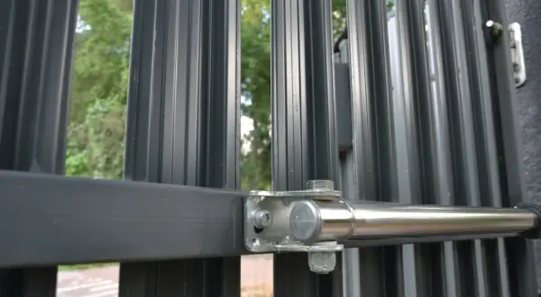 Metalowa brama z zamkiem z kodem, zabezpieczająca wejście do ogrodu.