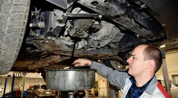 Mechanik wymienia olej w samochodzie. Pamiętaj, co ile wymieniać filtr oleju, by silnik działał sprawnie.