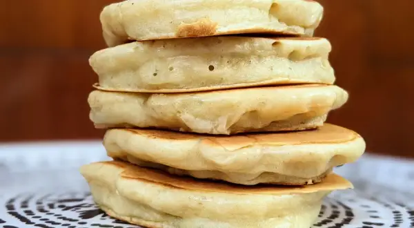 Pile de pancakes moelleux au fromage blanc, parfaits pour un petit-déjeuner gourmand.