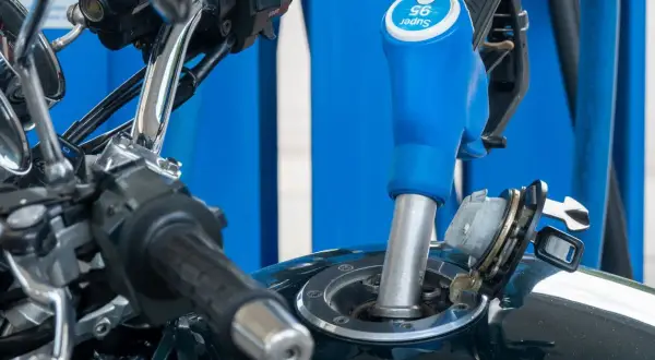Repostando la moto, ¿gasolina 95 o 98? La manguera de la gasolinera indica "Super 95".
