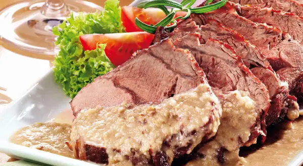 Saftiger Sauerbraten, in Scheiben geschnitten, mit cremiger Sauce und Beilagen. Perfekt für ein langes Schmoren, damit 1 kg Sauerbraten zart wird.