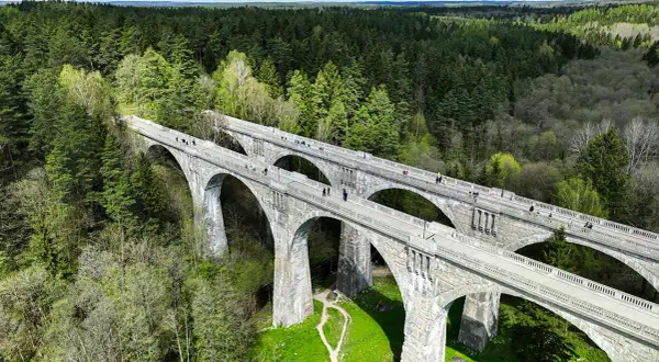 Kamienne wiadukty, dawna ścieżka rowerowa trasą kolejki wąskotorowej, otoczone bujnym lasem.