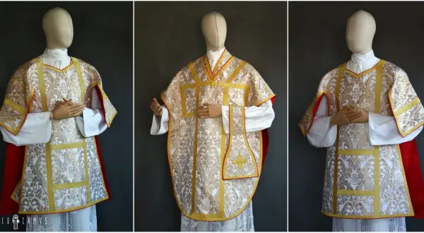 Elegancka wierzchnia szata liturgiczna z białego jedwabiu ze złotym haftem i czerwonym podszyciem.