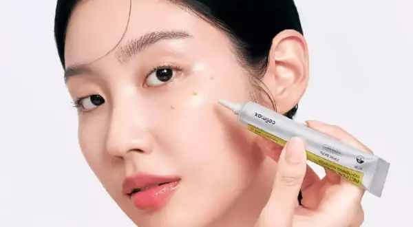 Une femme applique un sérum sur son visage. Le tube indique "RETINAL", suggérant une discussion sur la différence entre rétinol et rétinal.