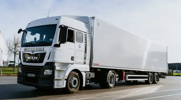 Camion blanc "Véhicule École" pour apprendre le permis poids lourd. Il est prêt pour la formation.