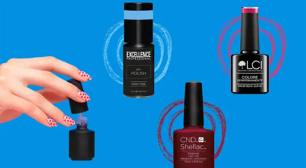 Una mano con unghie a cuore e flaconi di smalto semipermanente: blu, fucsia e bordeaux.