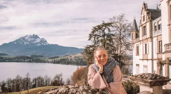 Frau genießt Aussicht auf See & Berge bei Luzern. Entdecke Luzern Geheimtipps von diesem malerischen Ort aus.