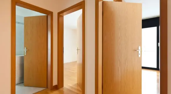 Pasillos con puertas de madera clara. Aprende como limpiar puertas de contrachapado para mantenerlas así de relucientes.