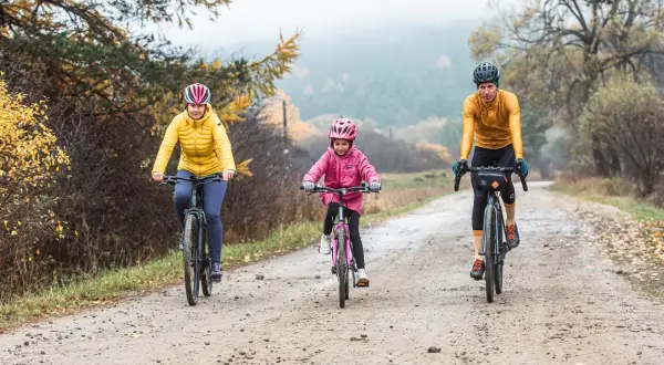 Rodzina na rowerach przemierza malowniczą dolinę Wisłoki jesienią.