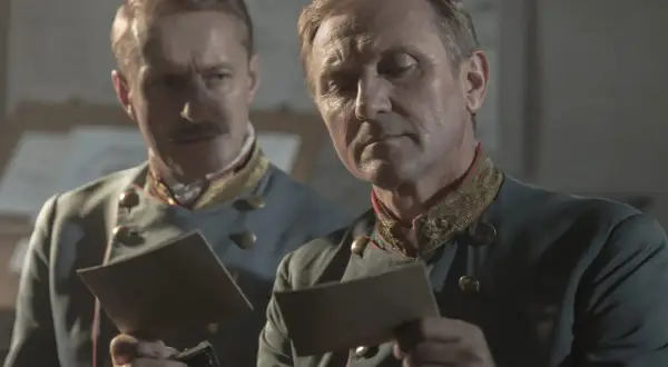 Dwóch mężczyzn w mundurach wojskowych analizuje dokumenty. Scena z filmu "Pacjentka", adaptacji książki.
