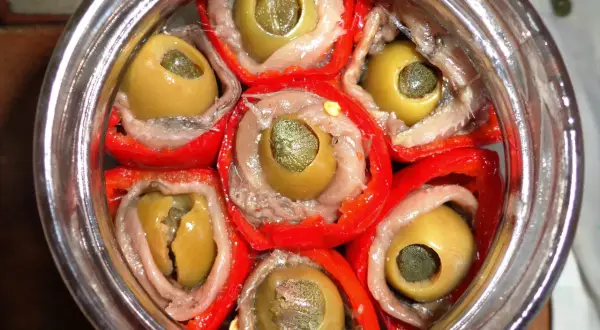 Peperoni sott'olio con acciughe e capperi, un antipasto saporito e colorato, pronto per essere gustato.