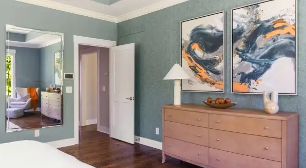 A tall dresser with a lamp, fruit bowl, and vase offers elegant tall dresser decor ideas.