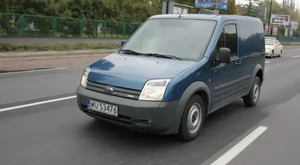 Niebieski Ford Transit 2018 na drodze, przygotowany do wymiany żarówki.