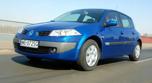 Niebieski Renault Megane 2 1.6 16v w ruchu, z widoczną tablicą rejestracyjną WE 0725G.