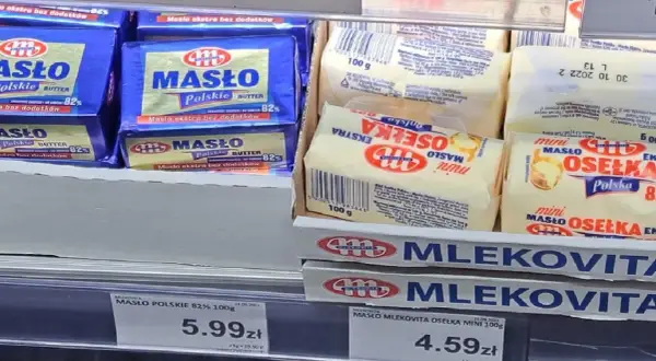 Na półce sklepowej widać opakowania masła. Jedno z nich, "Masło Polskie 82%", waży 100 gramów. Obok leżą mniejsze kostki masła "Osełka Mini" również po 100 gramów.