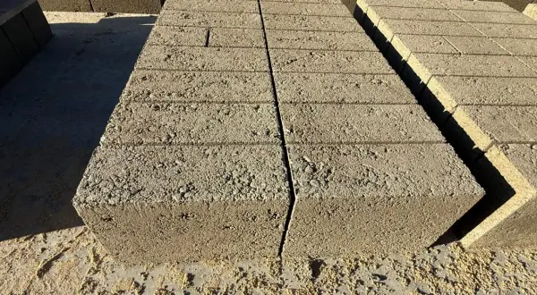 Stos bloczków fundamentowych, każdy z widocznymi kilkoma warstwami.